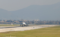 Un Boeing 767 della Delta Air Lines (volo per New York) in decollo dall'aeroporto di Pisa con la città sullo sfondo